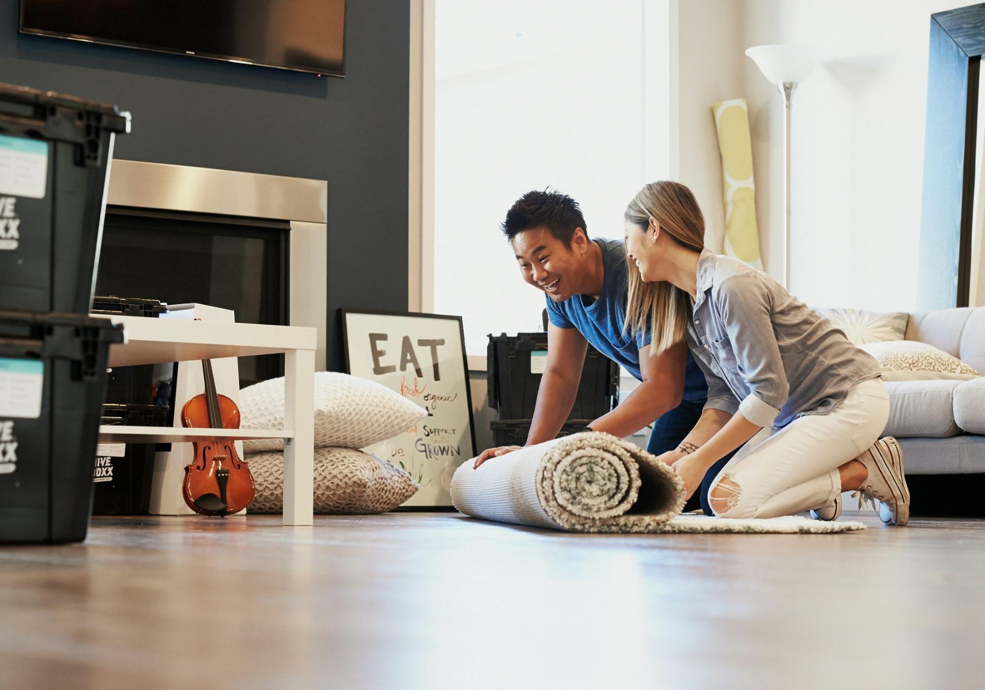 A couple rolling out a carpet